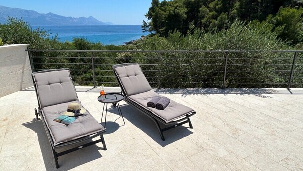 Two sun loungers with cushions and a small table with a drink, overlooking a body of water and mountains. - Villa Blue Bay with private pool (Selca)