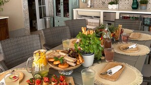 Un comedor con pared de piedra, techo de madera y una mesa de buffet con diversas comidas y bebidas.