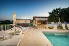 A poolside area with lounge chairs, a bar, and a grill. - Gloria Vita - villa with private pool and indoor jacuzzi (Nova Vas)