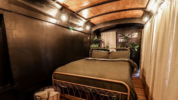 Ein kleines, gemütliches Schlafzimmer mit einem Einzelbett, einem Nachttisch und einem Korbwäscheschrank.