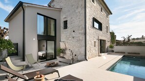 Relax in a serene outdoor space with a pool, patio, and garden.