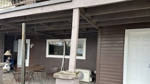 A covered outdoor area with a concrete floor, a white door, and a window. - Garden House, Unit B (Hot Springs)
