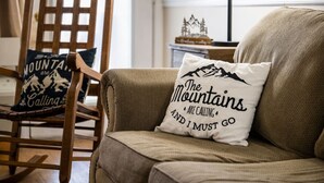 A wooden chair with a cushion that reads "The Mountains Are Calling and I Must Go." - 2BR w/MTN Views + Downtown Views! Community Pool - Walk to Parkway! (Gatlinburg)