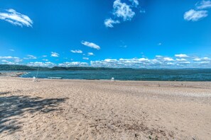 Una playa con cielo despejado y mar tranquilo.