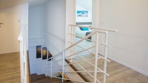A staircase with a white handrail leading to a bedroom with a bed and a window with a view of the sea. - Two bedroom apartment Milohanic III (Porec)