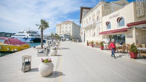 A waterfront promenade with outdoor seating, a restaurant, and a marina with boats. - Two bedroom apartment Milohanic III (Porec)