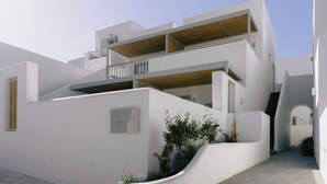 A modern white building with a wooden deck, a staircase, and a sign that reads "Mr & Mrs White". -  Mr and Mrs White Paros Suites and more (Paros)