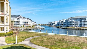 Un hôtel situé au bord de l’eau, doté de nombreux balcons, d’un port de plaisance et d’un canal.