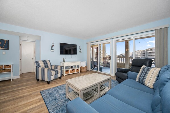 A living room with a blue sofa, striped armchair, and a wooden coffee table.