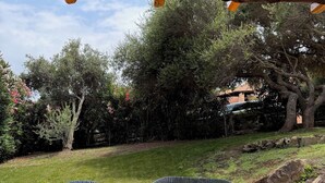 Une terrasse extérieure avec des meubles en osier et un sol carrelé.