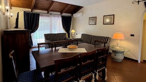 Un coin repas avec une table et des chaises en bois, un canapé et une lampe.