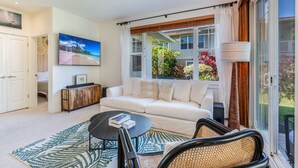 A living room with a sofa, a coffee table, and a television.