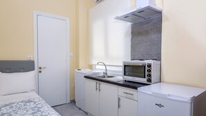 A compact kitchenette with a microwave, sink, and a small refrigerator.