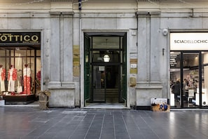 A building facade with storefronts, including visible signage for 'OTTICO' and 'SCIADELOCHIC'.