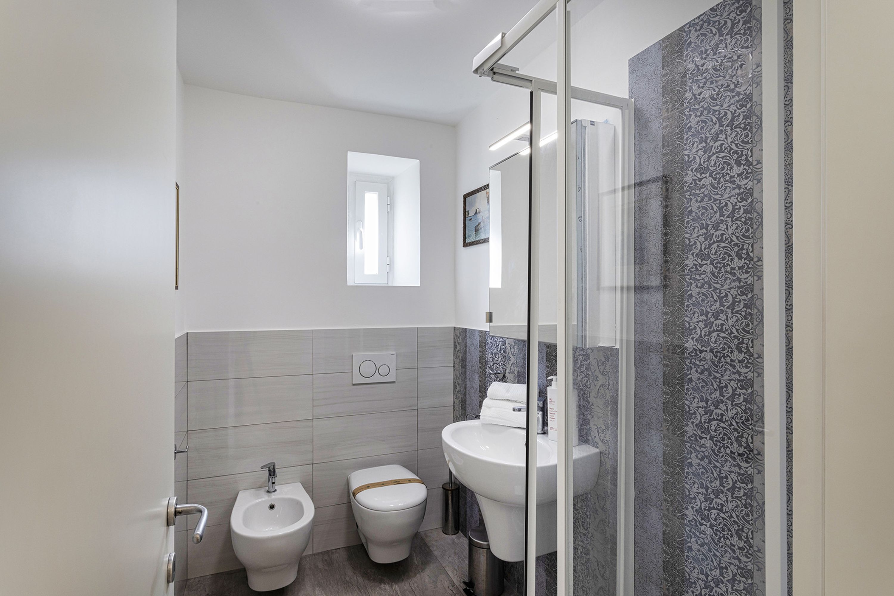 Un baño moderno con bidé, inodoro y lavabo.