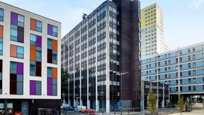 Ein modernes Gebäude mit einer Kombination aus Glas- und Betonfassaden, mit einer markanten Eckstruktur.