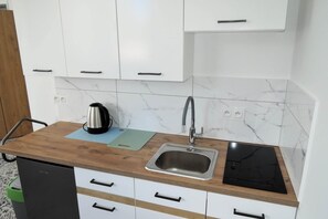 Frigorífico, placa de cocina, cafetera o tetera y mesa de comedor