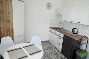 Kühlschrank, Herdplatte, Wasserkocher mit Kaffee-/Teezubehör, Esstisch