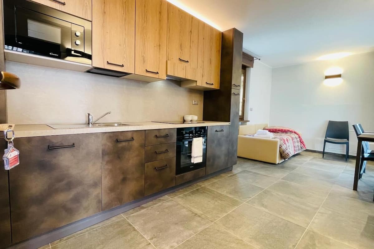 A modern kitchen with wooden cabinets, a built-in oven, and a microwave.