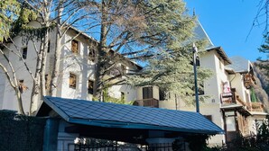 A traditional building with multiple windows and balconies, surrounded by trees and a clear blue sky. - Residence VILLA LINDA (Bardonecchia)
