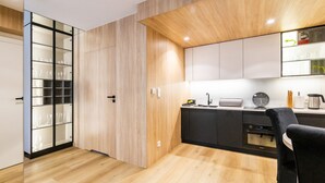 Una cocina moderna con armarios de madera, encimera negra y una silla negra.