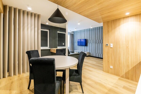 A modern conference room with a round table and chairs, a television, and a wooden ceiling. - Luxury 3-room apartment by the beach (Rowy)