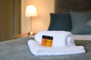 A neatly made white towel on a bed with two bottles of lotion placed on it. - Pet friendly  direct water access  3bed sleeps 6 (Fareham)