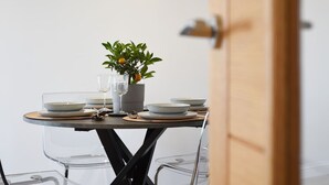 A dining table set with plates, glasses, and a potted plant.