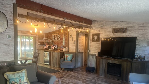 A cozy living room with a fireplace, a bar area, and a television.