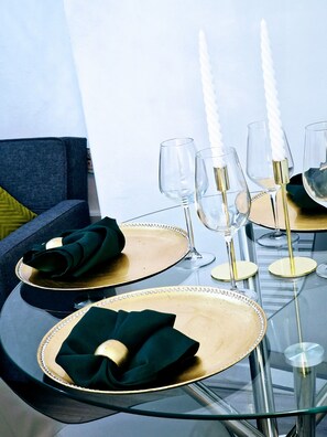 A dining table set with clear glassware, gold-rimmed plates, and green napkins. - London - 1 Bedroom - 1 Bathroom - Wifi (London)