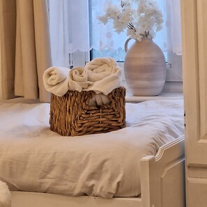 A neatly made bed with a woven basket containing rolled towels. - London - 1 Bedroom - 1 Bathroom - Wifi (London)