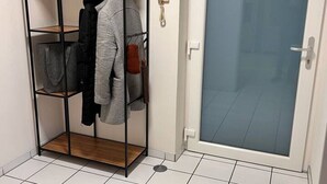 A room with a metal wardrobe, a door with a frosted glass panel, and a tiled floor. - Zeitwohnung Kenn/region Trier (Kenn)