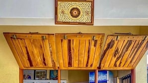 A bar area with wooden ceiling panels, shelves with bottles, and stools. - RESIDENCE AINA (Abomey-Calavi)