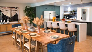 Una cocina moderna con una isla central, una mesa de comedor de madera y sillas.