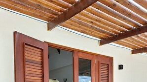 A wooden door with a glass panel, leading to an interior space with a tiled floor and a potted plant. - NEW! Villa La Brisa Aruba│Beautiful&Relaxing: Private pool,8-Min Stroll to Beach (Noord)