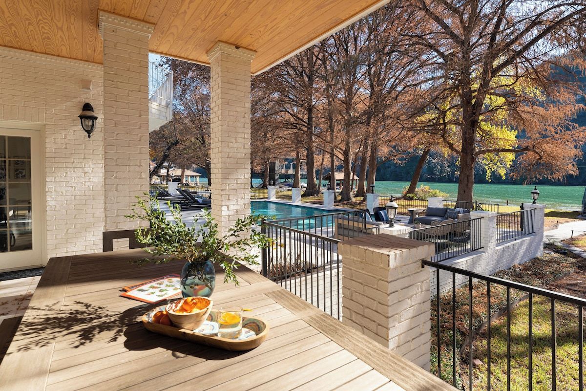 Un espace extérieur abrité comprenant une piscine, des chaises longues et une table à manger avec un plateau de nourriture.