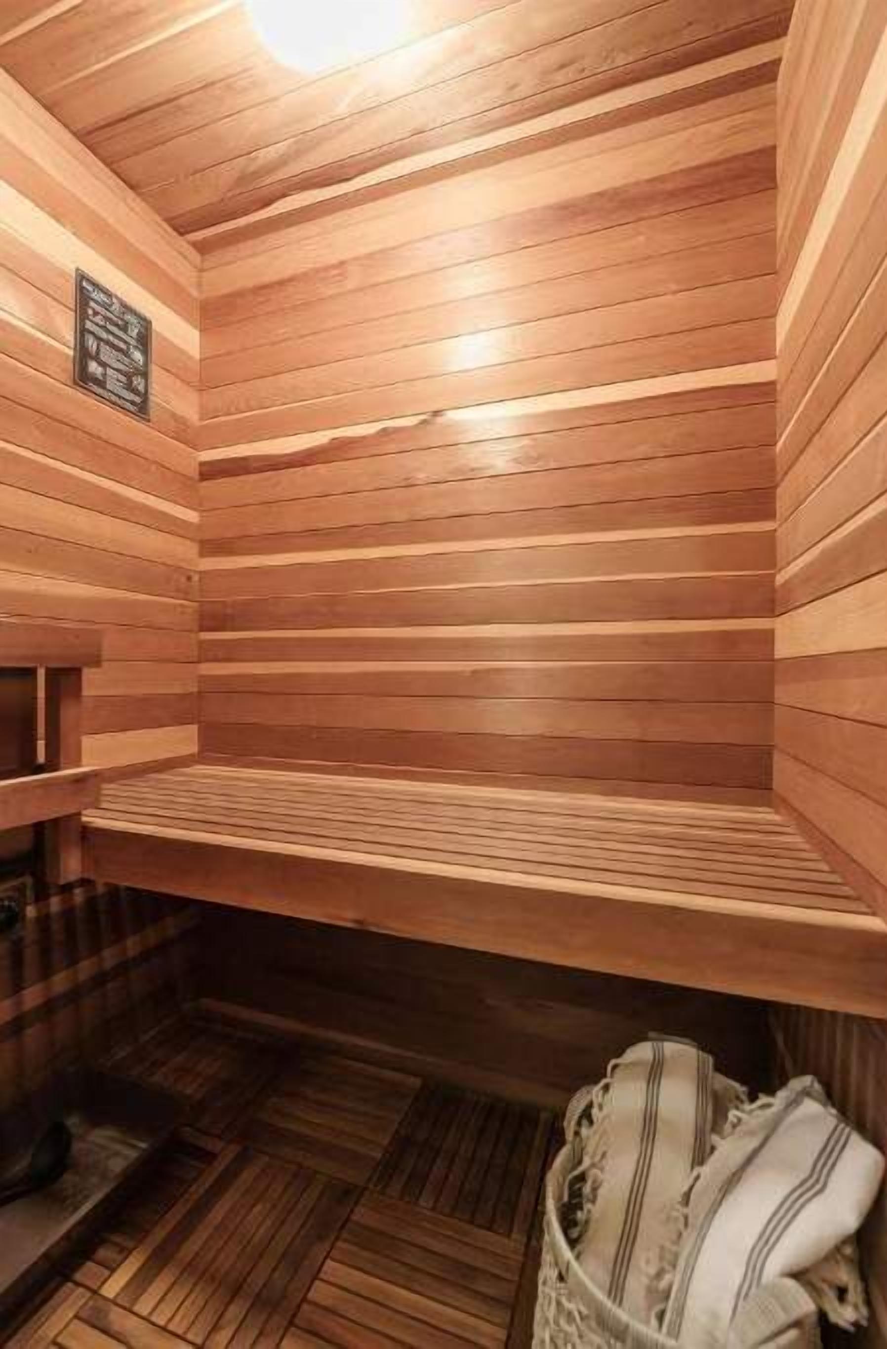 Un sauna avec des murs et des bancs en bois.