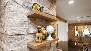 A stone wall with wooden shelves holding decorative items. - Indian Head Retreat  (Indian Head)