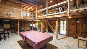 A spacious room with a billiards table, wooden furniture, and a mezzanine level with a railing. - Indian Head Retreat  (Indian Head)
