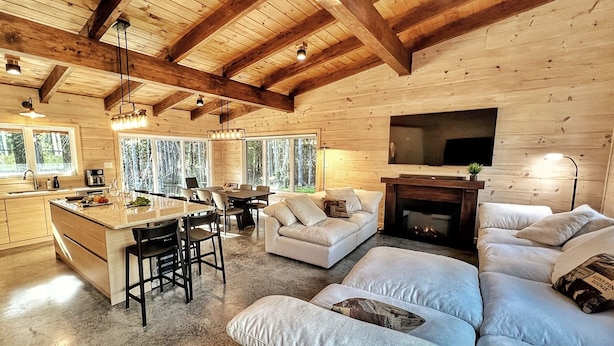 Interior de una cabaña de madera con cocina, comedor y sala de estar.