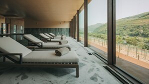 A spa area with reclining chairs and a large window overlooking a vineyard. - Torel Quinta da Vacaria - Douro Valley (Peso da Régua)