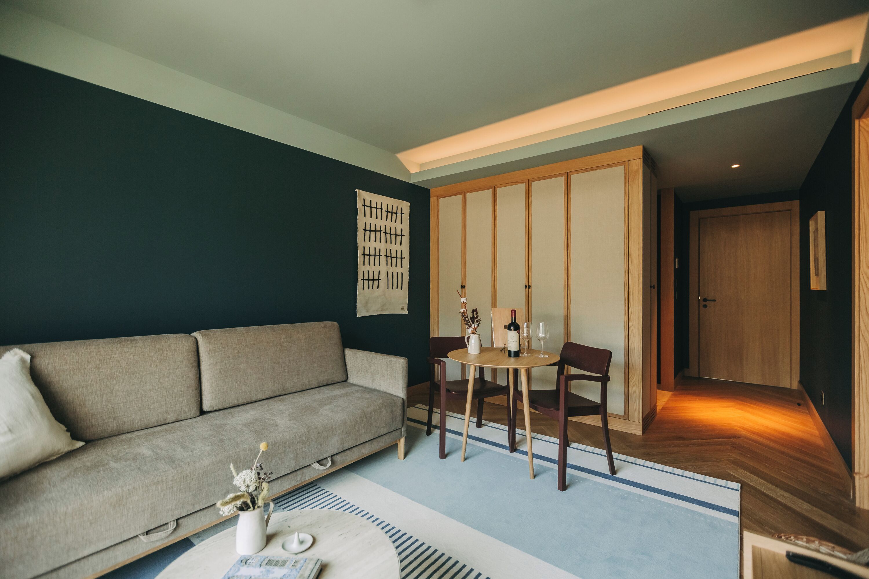 Un salon moderne comprenant un canapé, une table à manger avec des chaises et un meuble en bois.