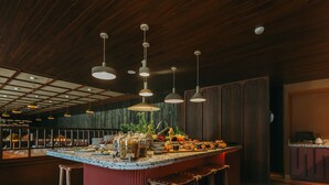 A restaurant interior with a central island, wooden flooring, hanging pendant lights, and stools. - Torel Quinta da Vacaria - Douro Valley (Peso da Régua)