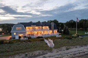 A large, two-story house with a covered porch and a flagpole. - The Beach Estate, Panoramic Ocean Views, 5700 sqft (Mattapoisett)