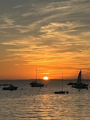 A sunset over a calm sea with several boats anchored. - Cabane Edena, Terrasse Ombragée Jardin Vélos Wifi à 350m de la Plage du Mauret (Andernos-les-Bains)