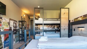 A dormitory-style room with bunk beds, a desk, and a bookshelf. - a&o Hostel Firenze Campo Di Marte (Florence)