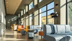 A spacious lobby with a modern design, featuring a large seating area with sofas and ottomans, a coffee table, and a floor lamp. - a&o Hostel Firenze Campo Di Marte (Florence)