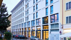 A modern building with multiple windows and a visible entrance. - a&o Hostel Firenze Campo Di Marte (Florence)