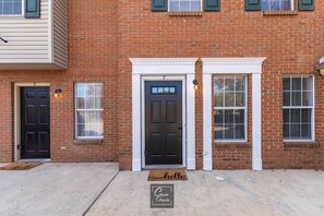 A brick building with two front doors, a 'hello' mat, and a 'Casa Oasis' sign. - Greenleaf Comfort Retreat 4 Beds Decatur (Decatur)