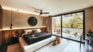 A modern bedroom with a large bed, a ceiling fan, and a view of a balcony with outdoor furniture. - Luxury Penthouse Miraluna 324 (Tulum)